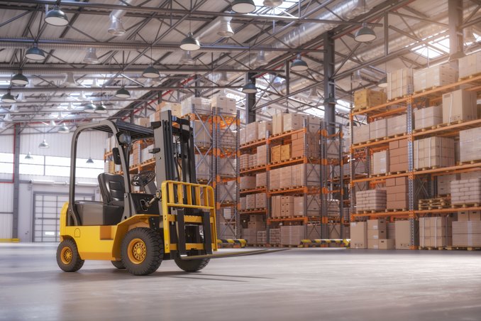 A counterbalance forklift standing on an open warehouse floor in front of pallet racking loaded with cartons — warehouse and distributor insurance in Utah