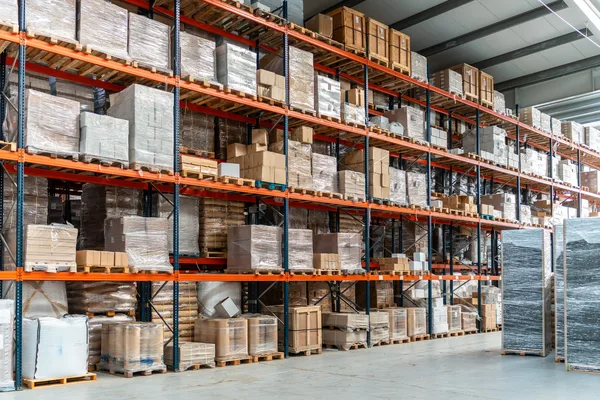 A run of pallet racking filled with wrapped pallets and cartons on several levels above floor-level stock — warehouse and distributor insurance in Iowa