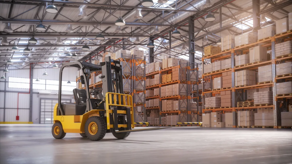 A counterbalance forklift standing on an open warehouse floor in front of pallet racking loaded with cartons — warehouse insurance in Illinois